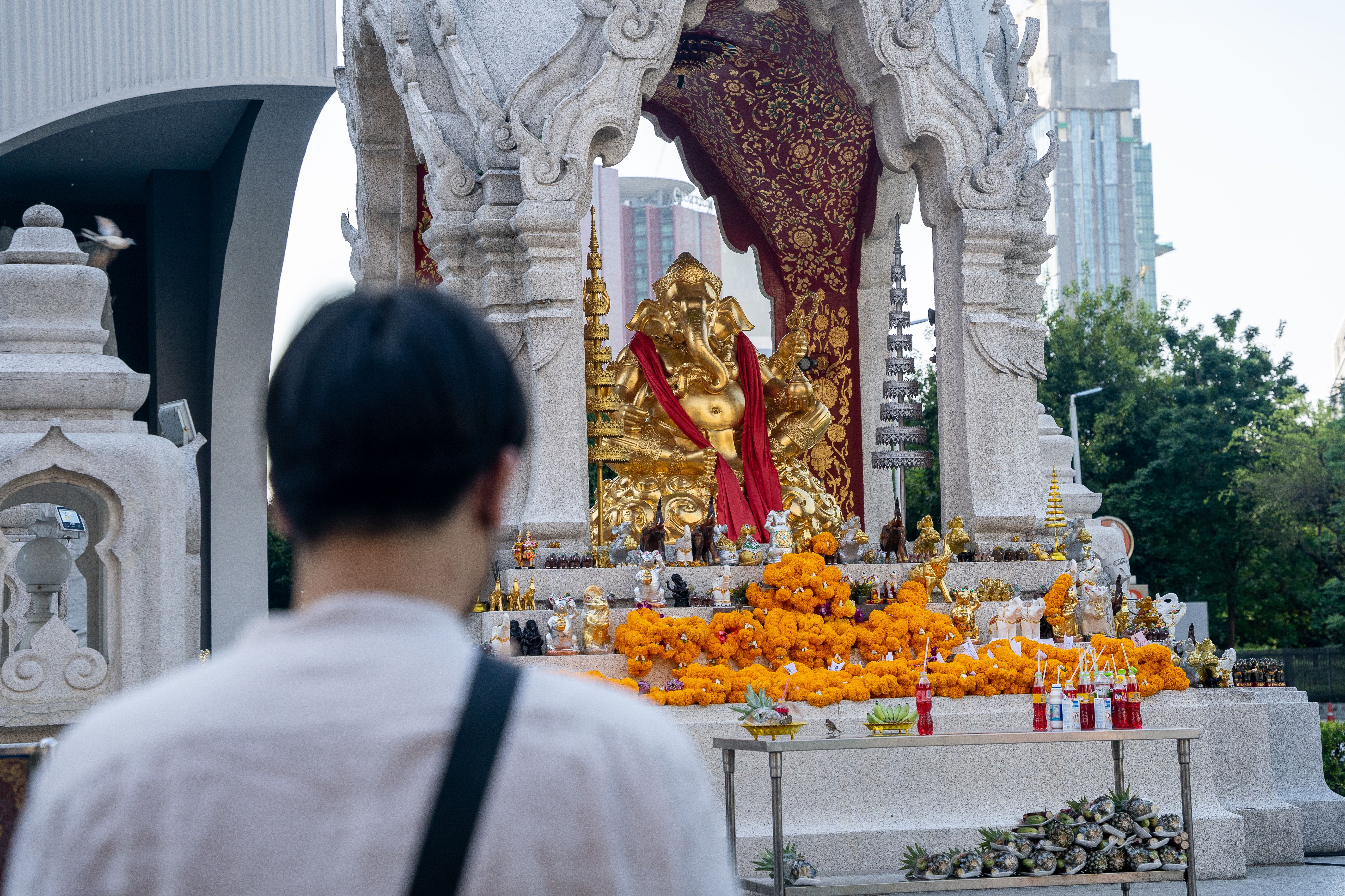 Man praying at a Buddhist shrine in Thailand. Photo by RJ Rempel.
