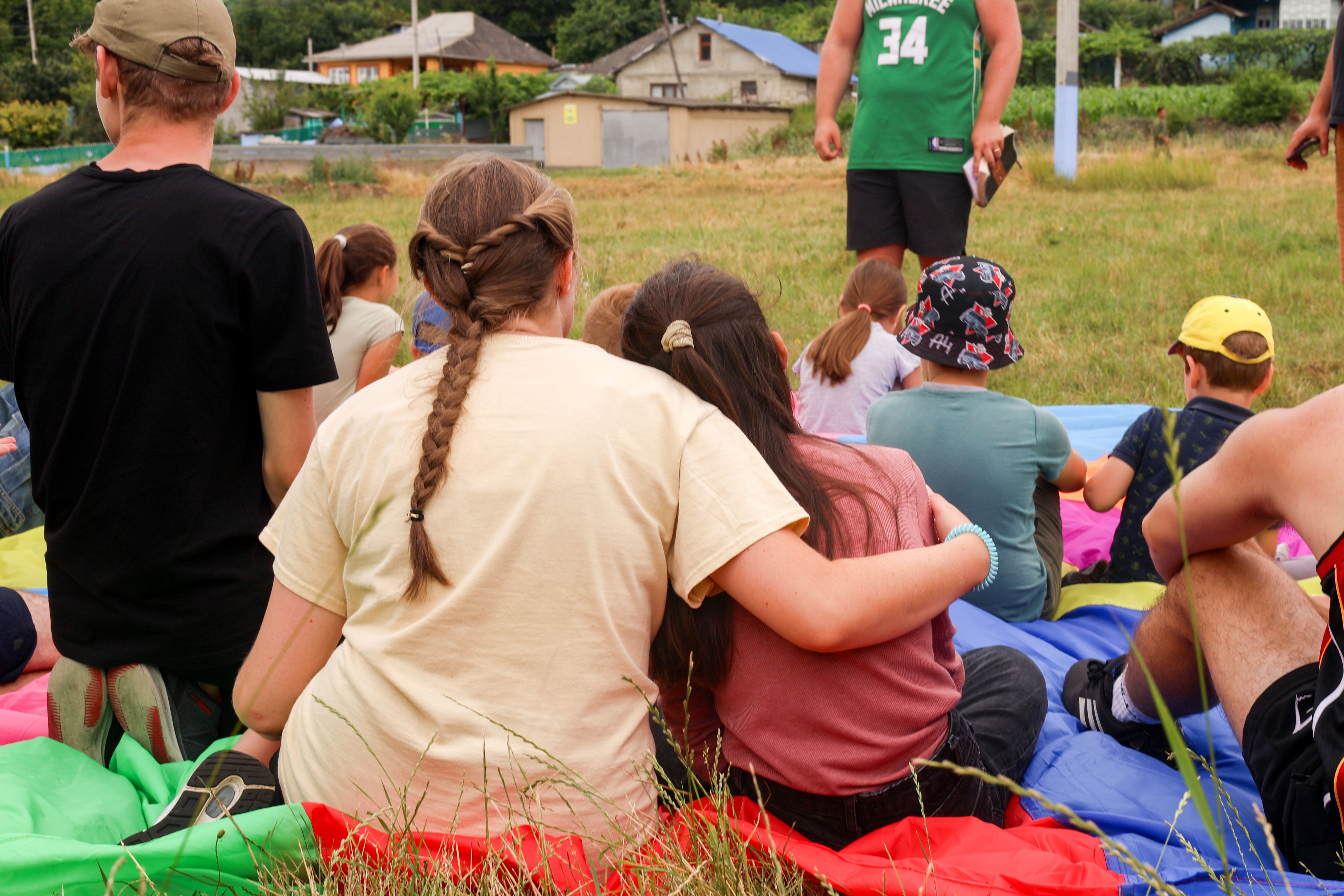 Two young women hugging during story time at a children's programme. Photo by Jordan Wilkinson.