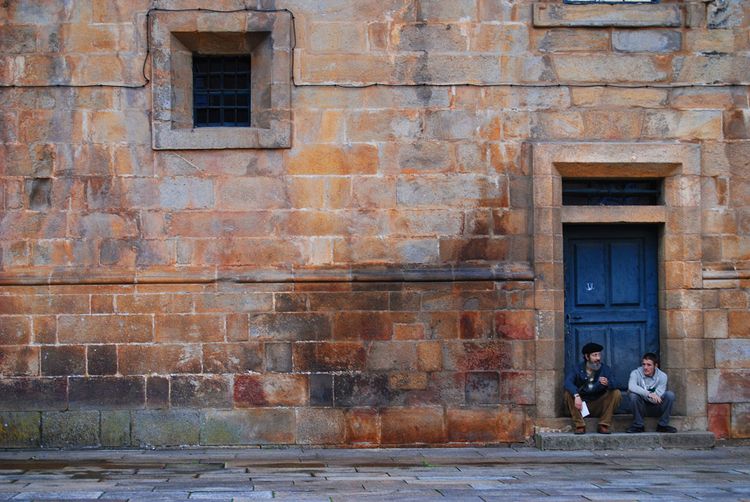 Two men rest at the completion point of the Camino de Santiago.  
Photo by Julia