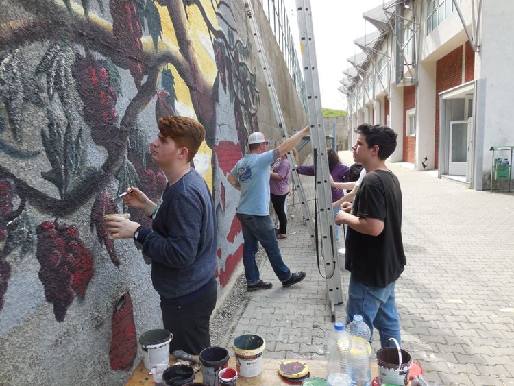 OM Incarnate artists collaborate with Kosovars to paint a mural in Suhareka, Kosovo.