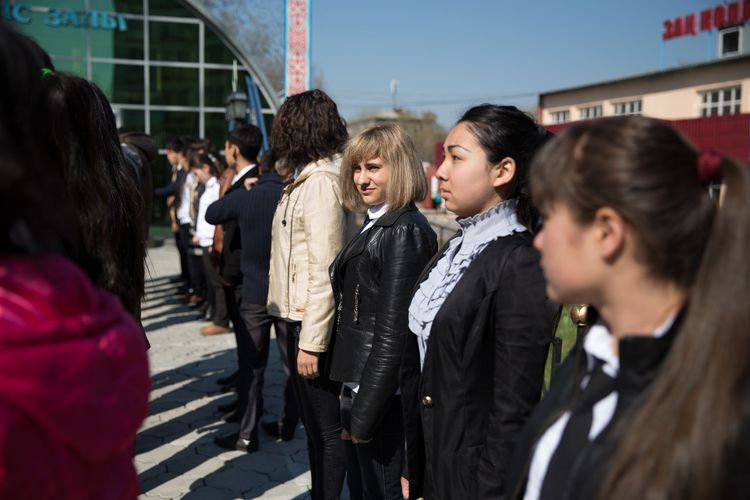 A group of Central Asian university students stand in a line.