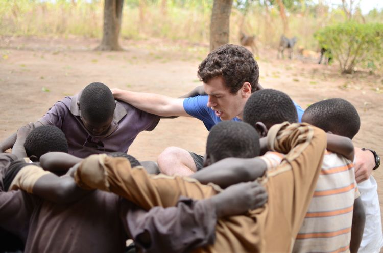 OMer prays with boys in Malawi.