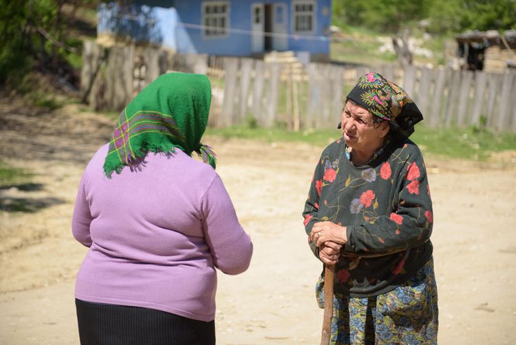 A congregant of a local village church in Moldova (left) speaks with a villager (right) during an outreach.