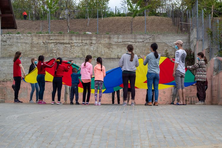 Participants of REACH in Moldova and Romania playing with children while on an outreach in Moldova.