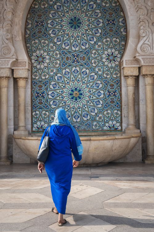 A woman walks by a decorative fountain outside the Hassan II Mosque in Casablanca, Morocco. The mosque is the largest in Africa. Photo by RJ Rempel.