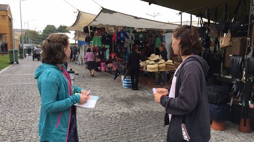 Transform team members give out tracts at a local market in Portugal.