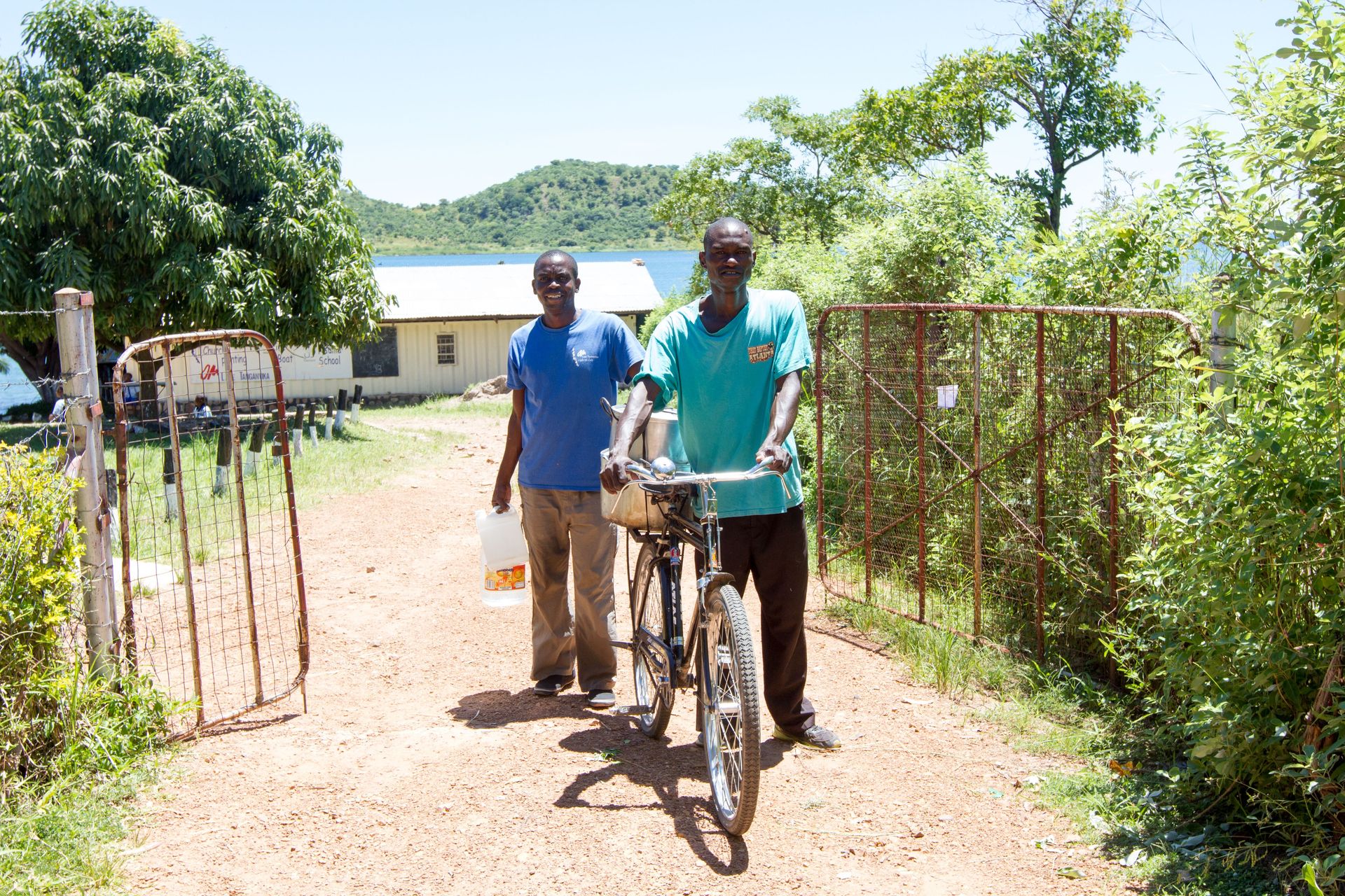 OMers Kaunda, left, and Alex load nshima and water onto a bike to take to the local prison. Three times a week OM Lake Tanganyika team members visit the prison to share the Word of God and provide a meal for the prisoners.