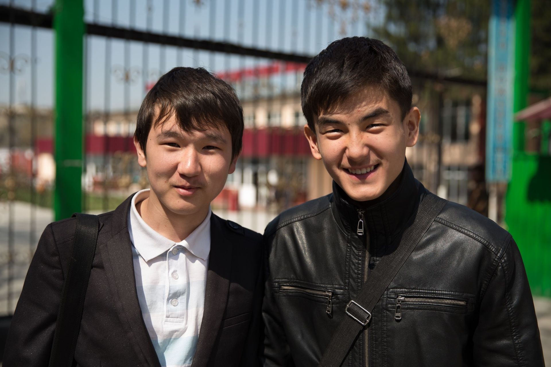 Two male university students in Central Asia smile for the camera.