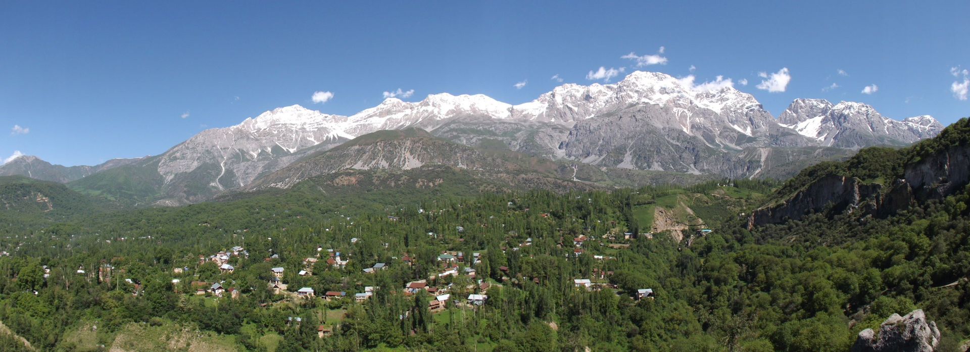 Mountain peaks loom over a small city in Central Asia.