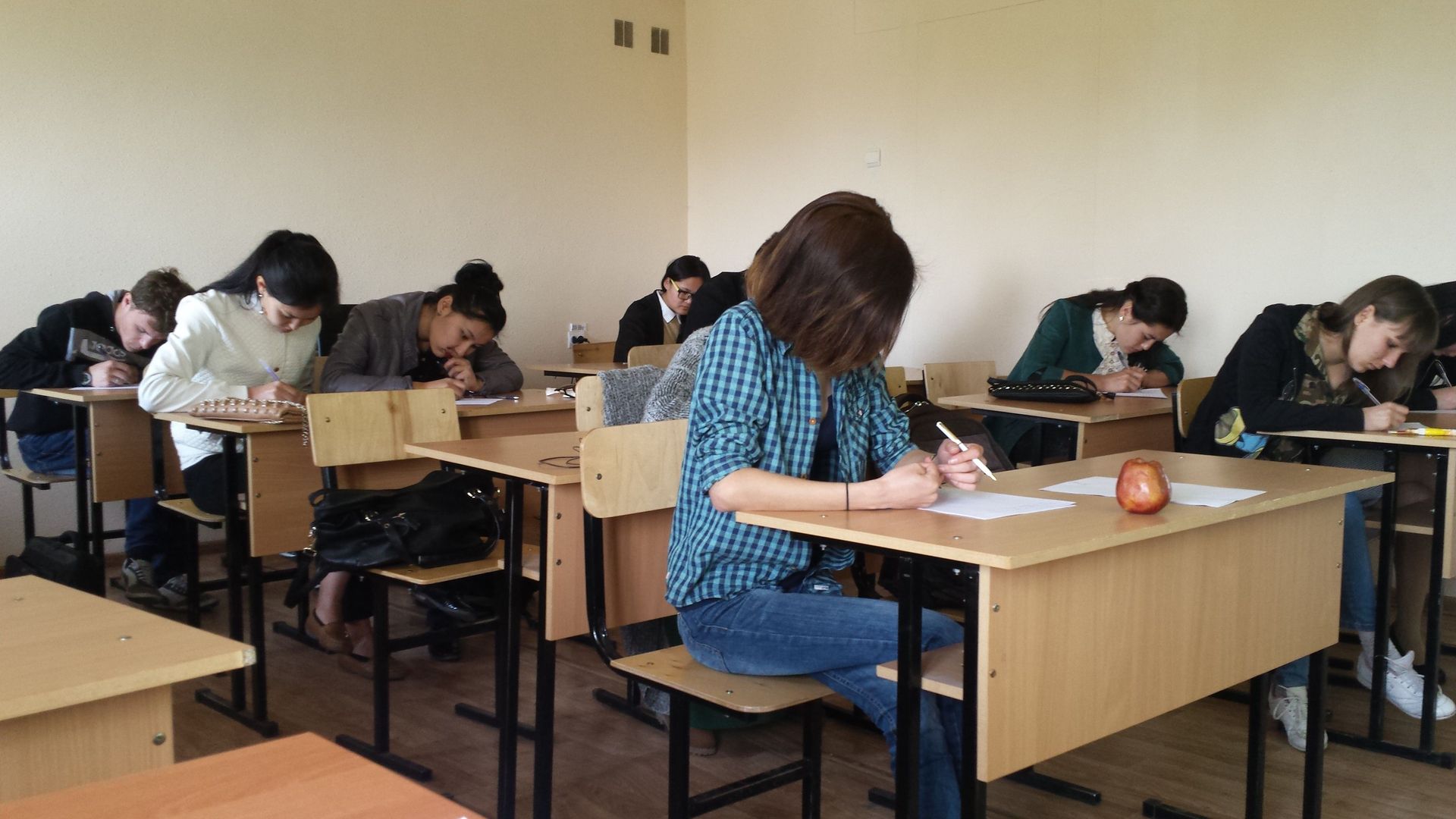 Central Asian university students working at their desks in a classroom