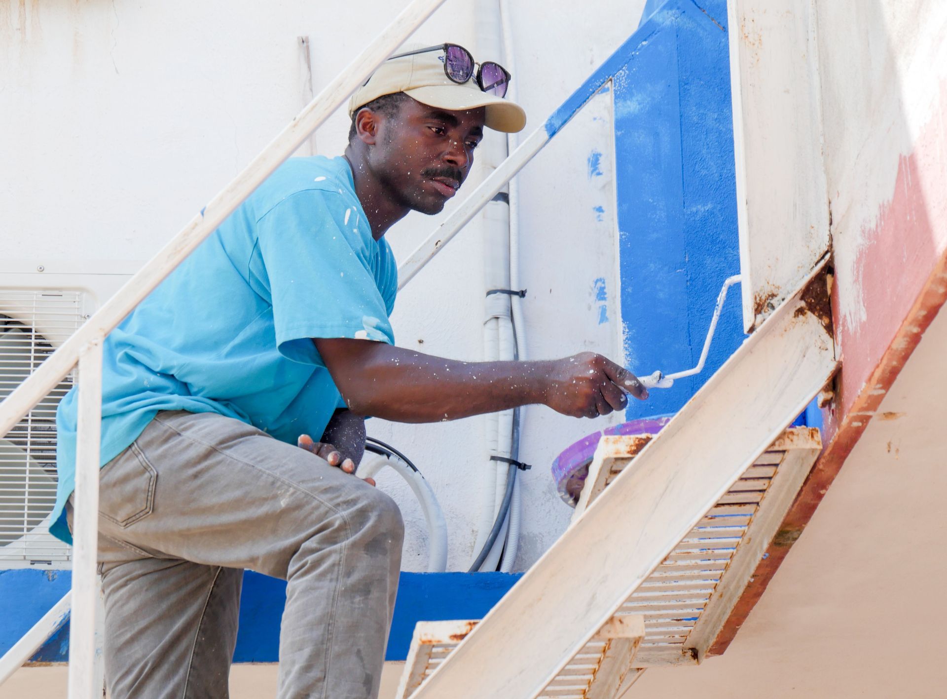 Progreso, Mexico :: Jean-Claude Mathieu (Haiti) paints the stairs of a community centre.