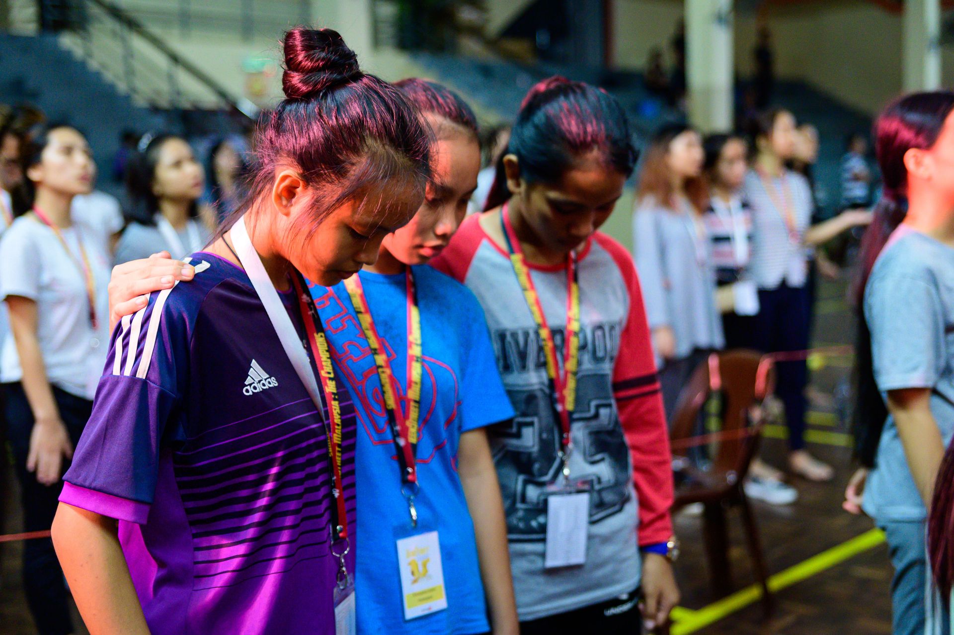 3 girls praying together at the opening ceremony