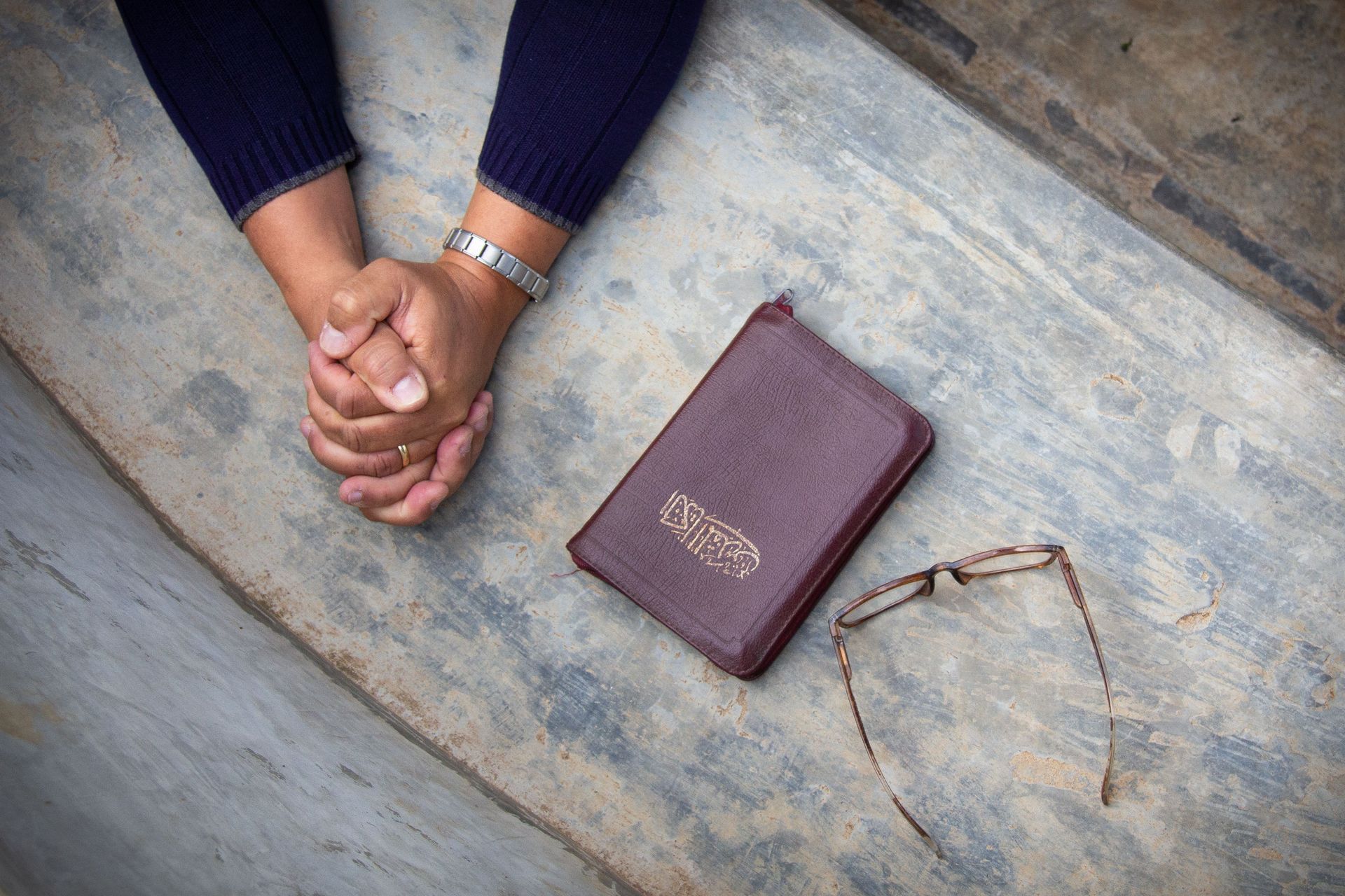 A worker is praying, kneeling next to an Arabic Bible, the language spoken in the area he serves in. Photo by Johanna Bird.