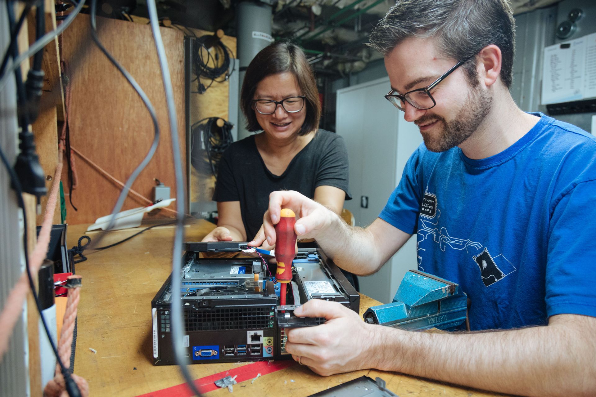 OM Ships :: IT specialist Frances Win (Australia) and Technology Services Department Head Beni Gartenmann (Switzerland) repair a computer as they are in charge of making sure that all computers, servers and desk-telephones on board are functional.