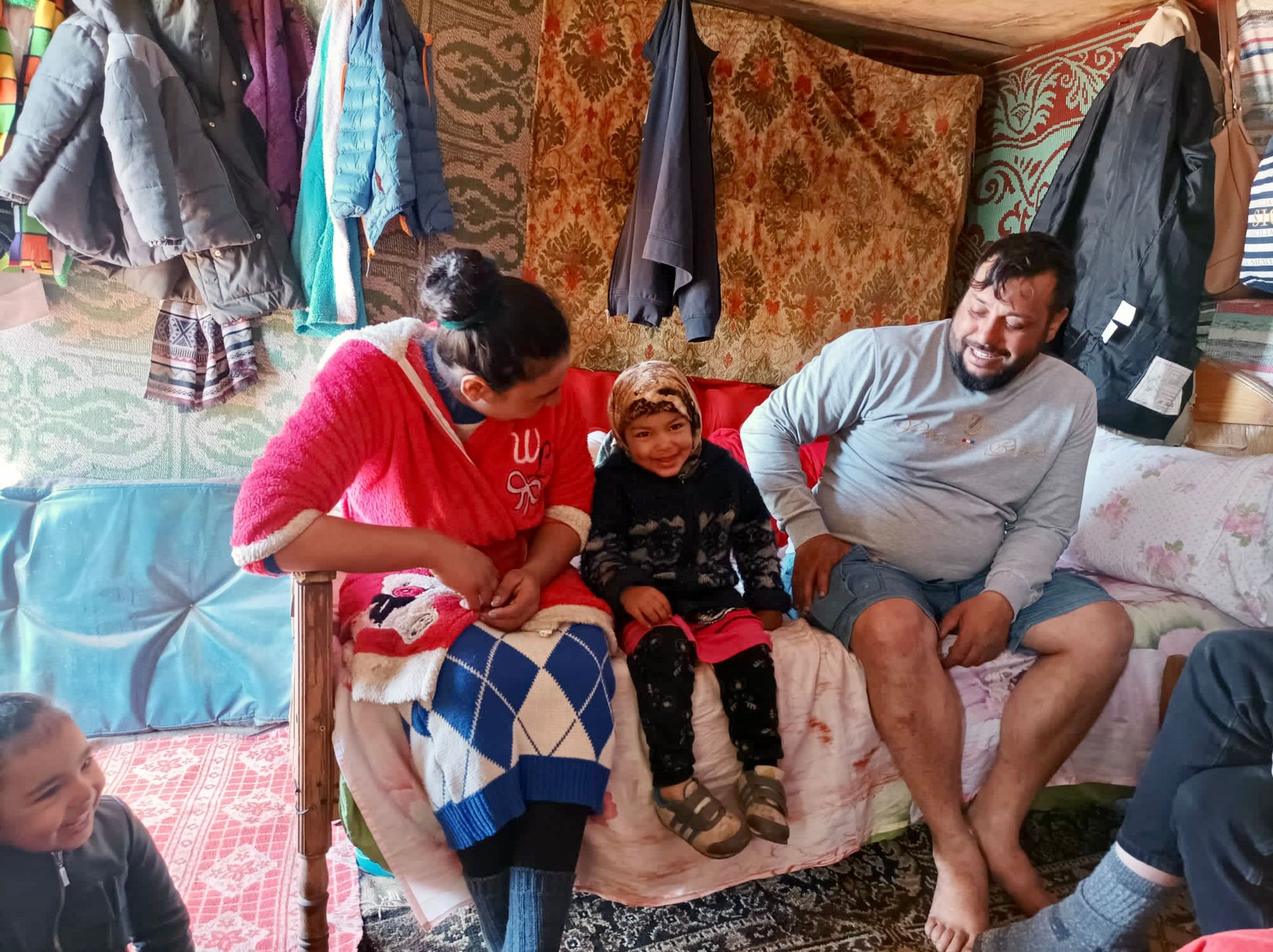 A local family sitting in their home talking to participants of REACH in Moldova and Romania during an outreach.