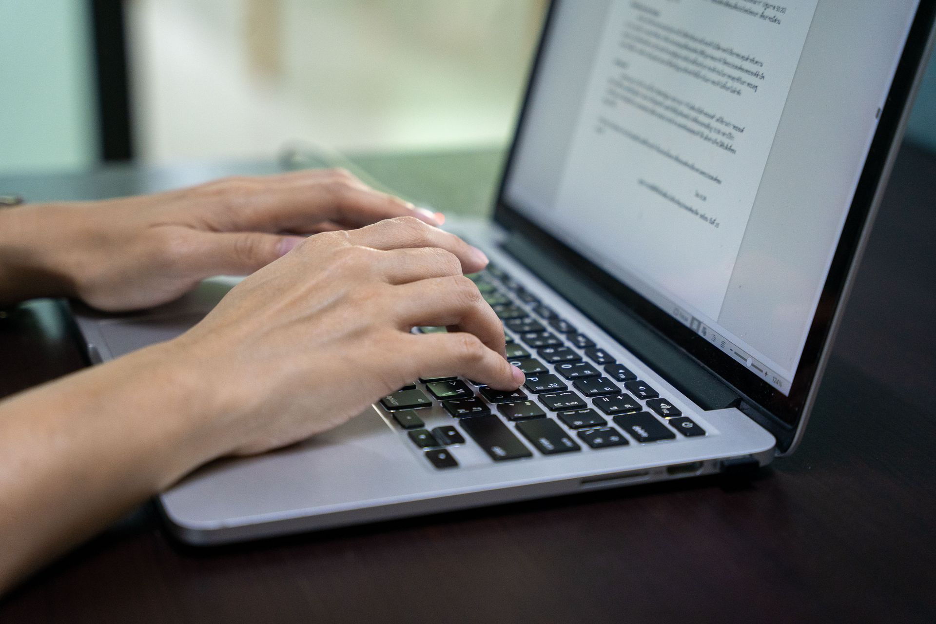 Hands typing on a Thai keyboard. Photo by RJ Rempel.