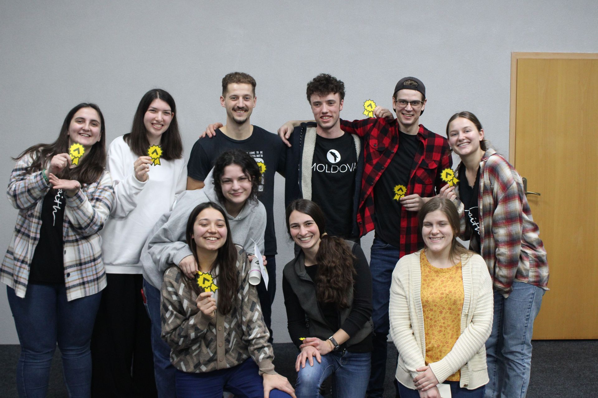 REACH in Moldova and Romania participants for 2023 pose for a group picture, holding little REACH signs.