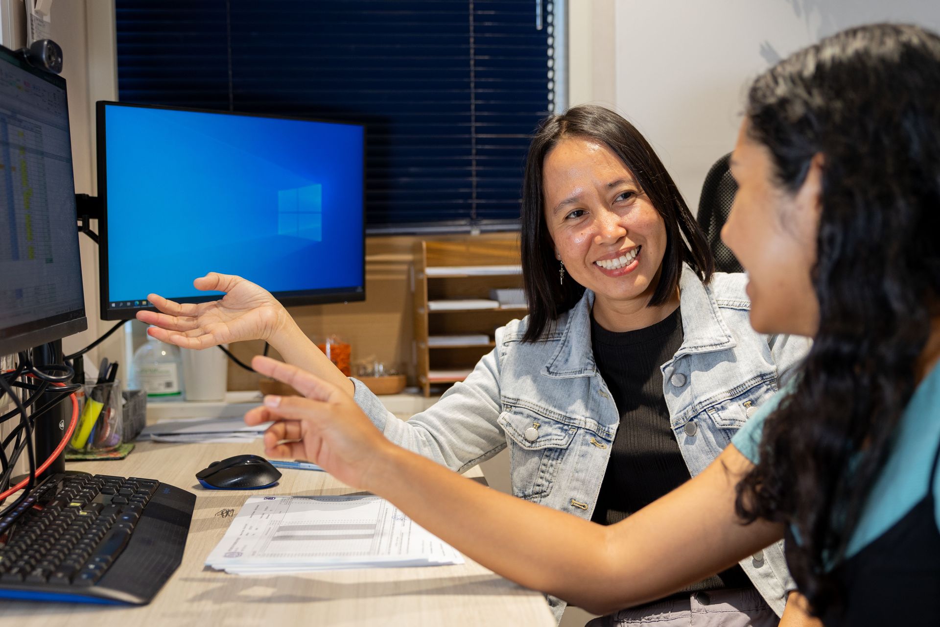 A woman from the Philippines (left) and a woman from Mexico work together in the finance office. Photo by RJ Rempel.
